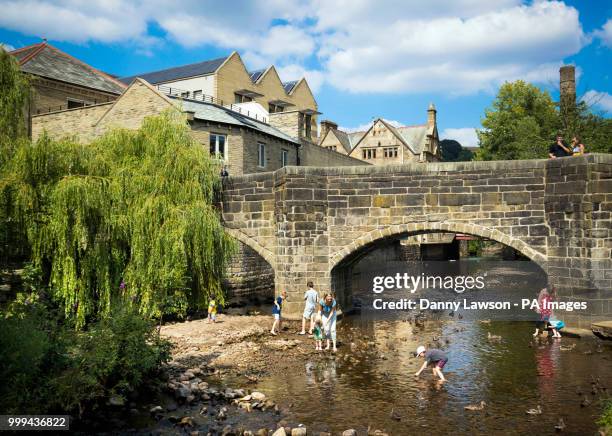 People paddling in Hebden Beck at Hebden Bridge, West Yorkshire, as hot weather continues across the UK.