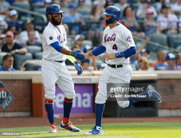 Wilmer Flores and Amed Rosario of the New York Mets in action against the at Citi Field on July 14, 2018 in the Flushing neighborhood of the Queens...