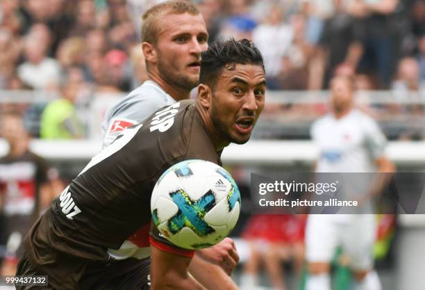 Heidenheim's Timo Beermann and St. Pauli's Aziz Bouhaddouz in action during the 2nd Bundesliga soccer match between FC St. Pauli and 1. FC Heidenheim...