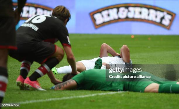 St. Pauli's Marc Hornschuh talks to Heidenheim's John Verhoek and Kevin Mueller after the 1:0 goal for St. Pauli during the 2nd Bundesliga soccer...