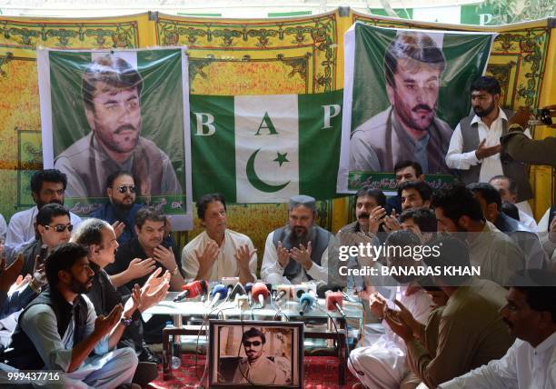 Pakistani cricketer-turned-politician and head of the Pakistan Tehreek-i-Insaf Imran Khan prays along with others for Siraj Raisani, a candidate of...