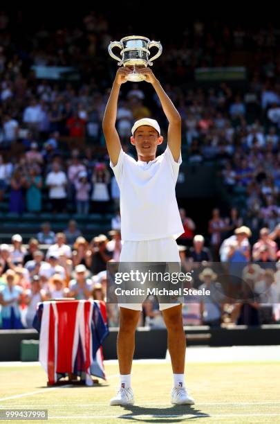 Chun Hsin Tseng of Taiwan celebrates with the trophy after defeating Jack Draper of Great Britain to win the Boys' Singles final on day thirteen of...