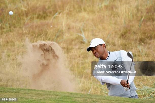 Tiger Woods of the United States plays out a bunker on the 1st hole while practicing during previews to the 147th Open Championship at Carnoustie...