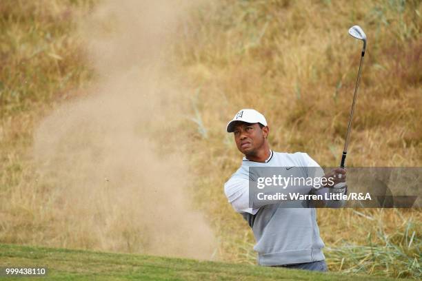 Tiger Woods of the United States plays out a bunker on the 1st hole while practicing during previews to the 147th Open Championship at Carnoustie...