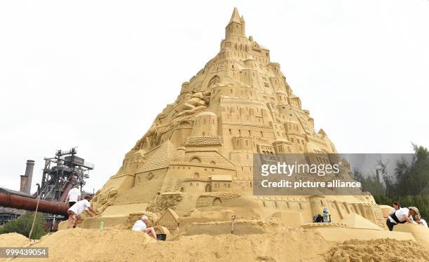 Dpatop - Artists work on the biggest sandcastle in the world at the landscape park in Duisburg, Germany, 26 August 2017. The artists want to enter...