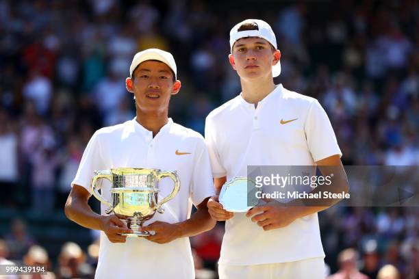 Chun Hsin Tseng of Taiwan and Jack Draper of Great Britain pose with their tropies after the Boys' Singles final on day thirteen of the Wimbledon...
