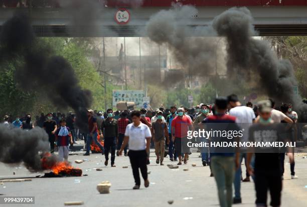 Protesters burn tyres during a demonstration against unemployment and a lack of basic services, in the southern Iraqi city of Basra on July 15, 2018....