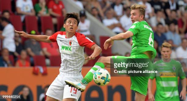 Augsburg's Ja-Cheol Koo and Gladbach's Christoph Kramer in action during the Bundesliga soccer match between FC Augsburg and Borussia...