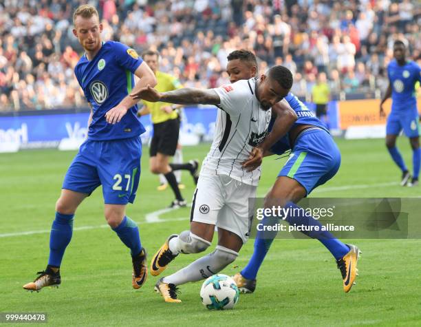 Frankfurt's Kevin-Prince Boateng and Wolfsburg's Ohis Felix Uduokhai and Maximilian Arnold in action during the Bundesliga soccer match between...