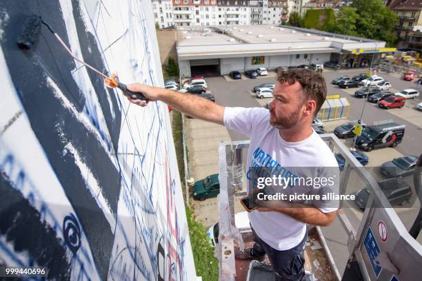 The Australian Street Artist Fintan Magee paints an artwork on the exterior of a wall in Saabruecken, Germany, 25 April 2017. It is one of twelve art...