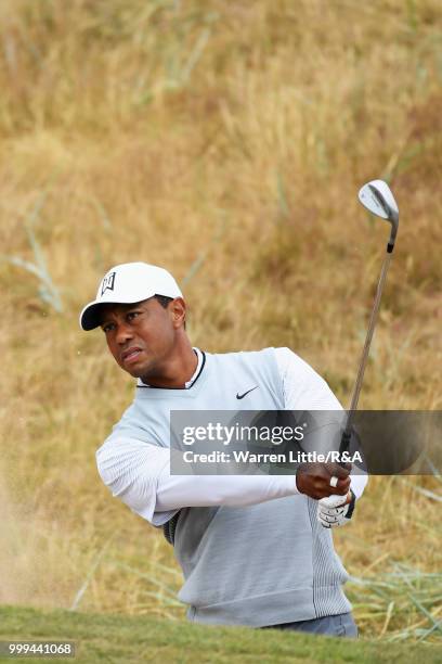 Tiger Woods of the United States plays out a bunker on the 1st hole while practicing during previews to the 147th Open Championship at Carnoustie...