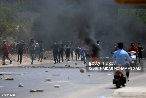 Protesters burn tyres during a demonstration against unemployment and a lack of basic services, in the southern Iraqi city of Basra on July 15, 2018....