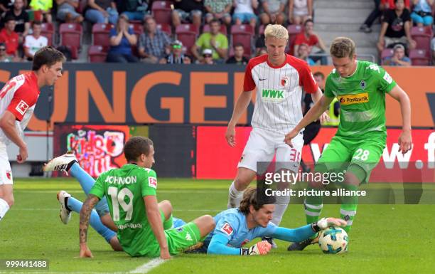 Augsburg's goalkeeper Marwin Hitz catches the ball next to Fabian Johnson and Matthias Ginter during the Bundesliga soccer match between FC Augsburg...