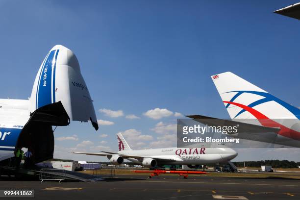 Volga-Dnepr Group air cargo aircraft, left, a cargo aircraft, operated by Qatar Airways, and the tail fin of a Boeing Co. 747 cargo aircraft, sit on...