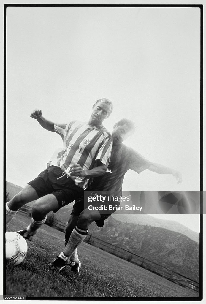Football, player and defender competing for ball (B&W)