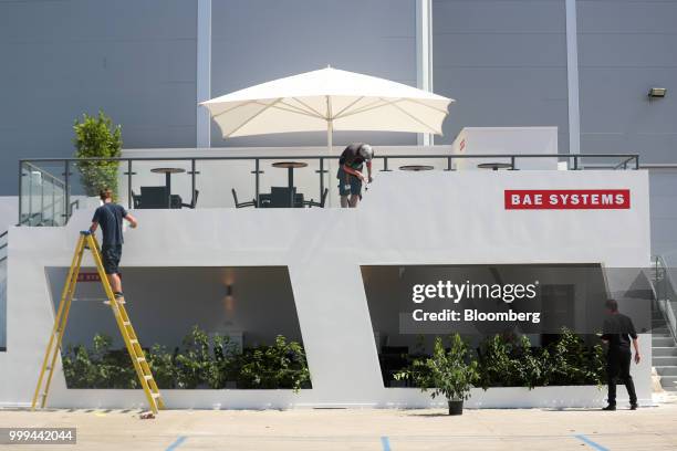 Workers make the finishing touches on the BAE Systems Plc stand during preparations ahead of the Farnborough International Airshow 2018 in...