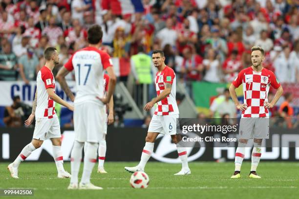 Dejan Lovren, and Ivan Rakitic of Croatia look dejected after their side concede during the 2018 FIFA World Cup Final between France and Croatia at...