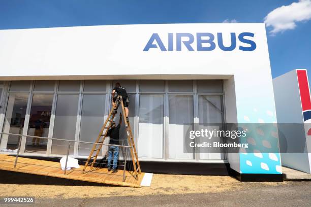 Workers make the finishing touches to the Airbus SE stand during preparations ahead of the Farnborough International Airshow 2018 in Farnborough,...