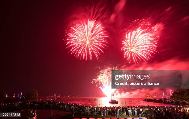 Visitors watch the traditional fireworks of the festival weekend 'Steinhuder Meer in Flammen' at the Steinhude Lake in Steinhude, Germany, 26 August...