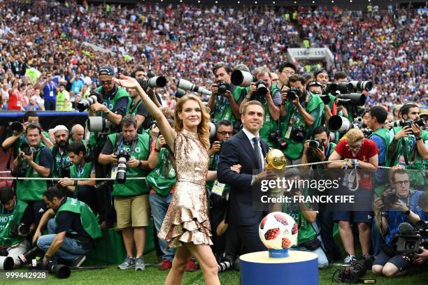 Germany's former captain Philipp Lahm and Russian model Natalia Vodianova pose with the World Cup trophy during the closing ceremony of the Russia...