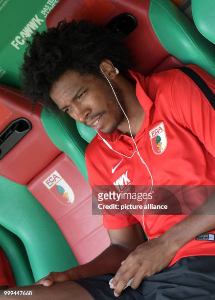 Augsburg's Caiuby sitting on the replacements' bench and listening to music during the Bundesliga match pitting FC Augsburg vs Borussia...