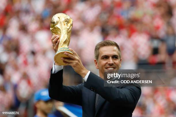 Germany's former captain Philipp Lahm poses with the trophy during the closing ceremony prior to the Russia 2018 World Cup final football match...