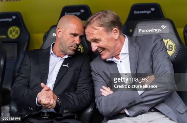 Dortmund head coach Peter Bosz and the club's managing director, Hans-Joachim Watzke, sitting on the coach's bench ahead of the Bundesliga match...
