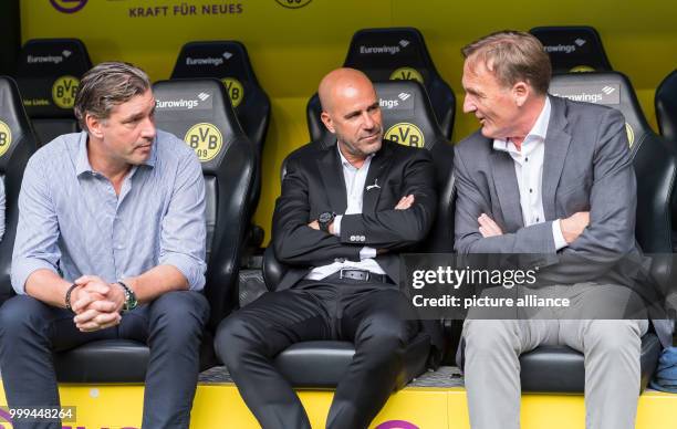 Dortmund managing director, Hans-Joachim Watzke , head coach Peter Bosz and head of sports Michael Zorc sitting on the coach's bench ahead of the...