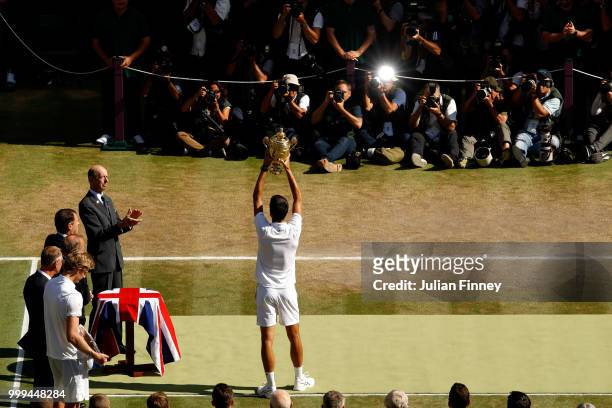 Novak Djokovic of Serbia lifts the trophy after winning the Men's Singles final against Kevin Anderson of South Africa on day thirteen of the...
