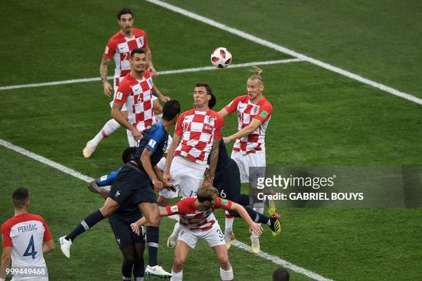Croatia's forward Mario Mandzukic heads the ball and scores an own goal after France's forward Antoine Griezmann shot a free kick during the Russia...
