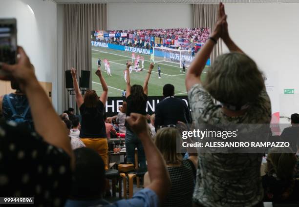 People react at the media center in Helsinki as France scores a goal during the Russia 2018 World Cup final football match between France and...