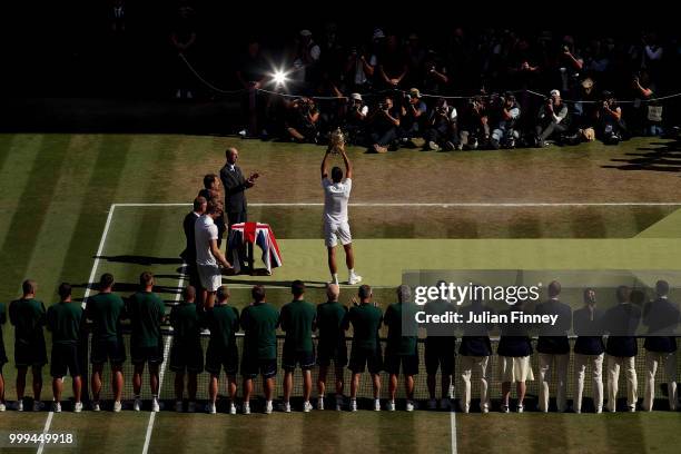 Novak Djokovic of Serbia lifts the trophy after winning the Men's Singles final against Kevin Anderson of South Africa on day thirteen of the...