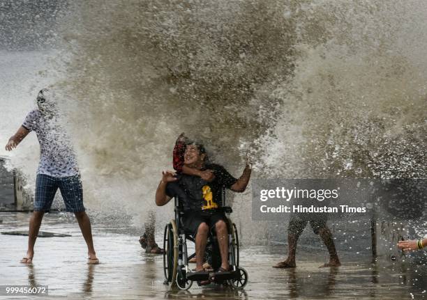People enjoy high tide at Worli Seaface, on July 14, 2018 in Mumbai, India. Mumbaikars had to face another tough battle, as the high tide hit the...