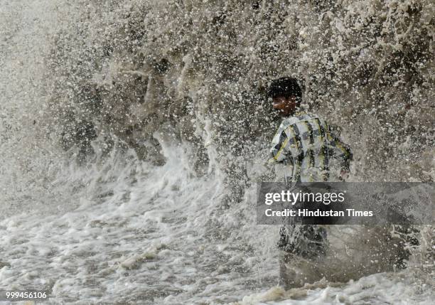 People enjoy high tide at Dadar, on July 14, 2018 in Mumbai, India. Mumbaikars had to face another tough battle, as the high tide hit the city at...