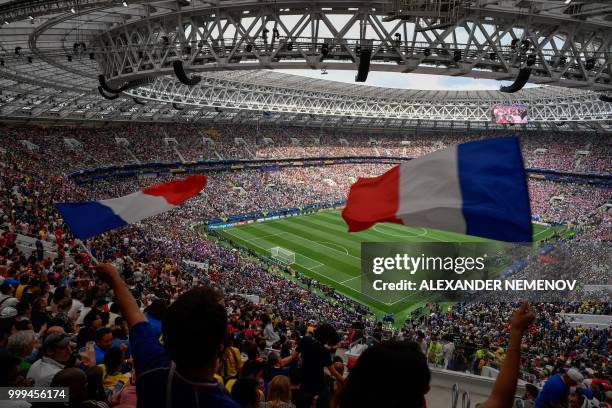 France's fans wave French national flag as teams enters the football pitch prior to the Russia 2018 World Cup final football match between France and...