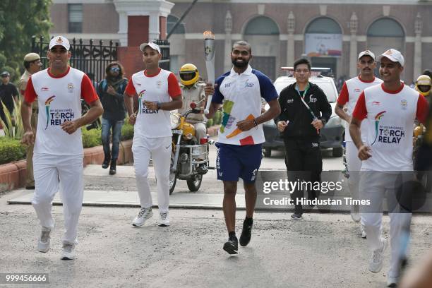 India hockey team captain P R Sreejesh holds the torch as the 'Torch Relay' begins for the 18th Asian Games Jakarta Palembang 2018, after the flame -...