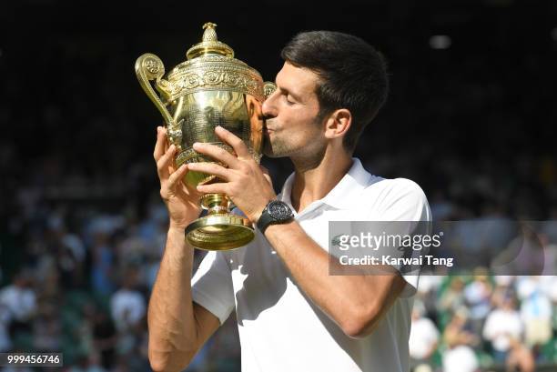 Novak Djokovic kisses the trophy after winning the men's singles final on day thirteen of the Wimbledon Tennis Championships at the All England Lawn...