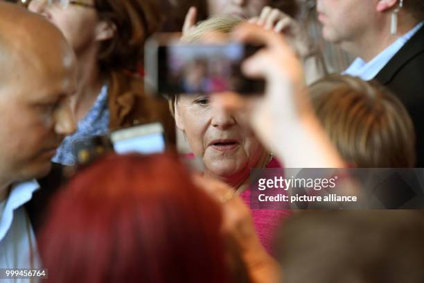 German Chancellor Angela Merkel lets visitors take a picture of her during the Open Day at the German federal government in the Federal Chancellery...