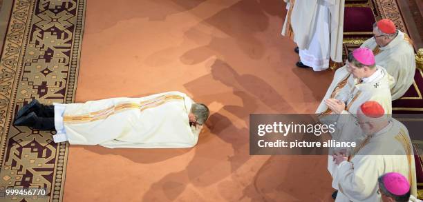 Peter Kohlgraf lies on the ground in front of Cardinal Karl Lehmann , archbishop Stephan Burger and Cardinal Reinhard Marx during the litany at his...