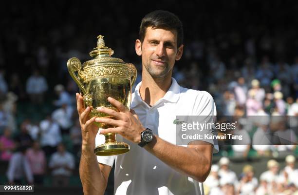 Novak Djokovic celebrates with the trophy after winning the men's singles final on day thirteen of the Wimbledon Tennis Championships at the All...
