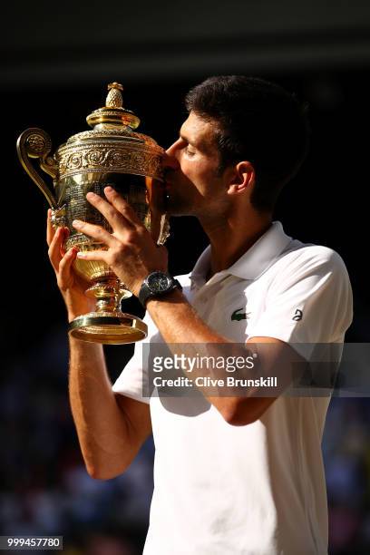Novak Djokovic of Serbia kisses the trophy after winning the Men's Singles final against Kevin Anderson of South Africa on day thirteen of the...