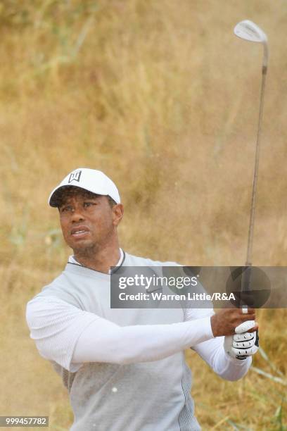 Tiger Woods of the United States plays out a bunker on the 1st hole while practicing during previews to the 147th Open Championship at Carnoustie...