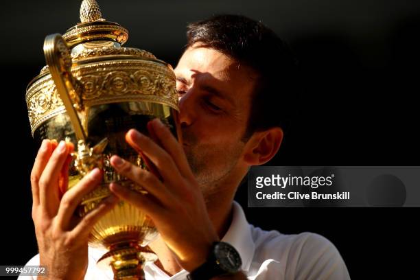 Novak Djokovic of Serbia kisses the trophy after winning the Men's Singles final against Kevin Anderson of South Africa on day thirteen of the...
