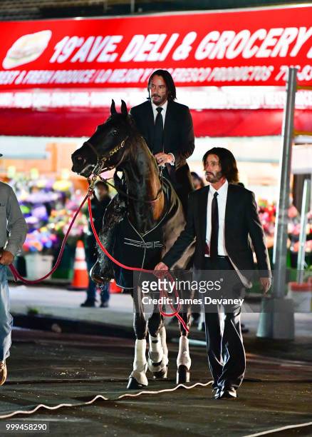 Keanu Reeves and his stunt double seen with a horse on location for 'John Wick 3' in Brooklyn on July 14, 2018 in New York City.