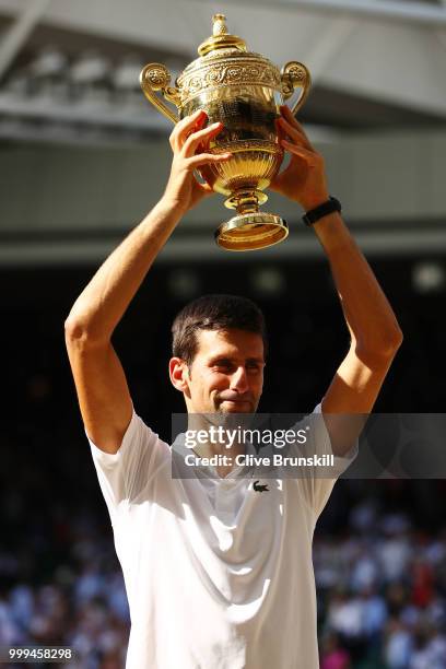 Novak Djokovic of Serbia lifts the trophy after winning the Men's Singles final against Kevin Anderson of South Africa on day thirteen of the...