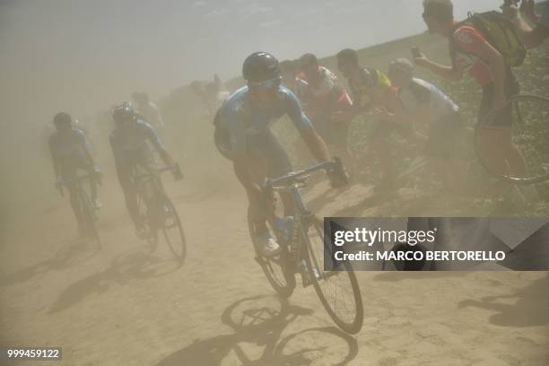 Riders pedal through a cobblestone section during the ninth stage of the 105th edition of the Tour de France cycling race between Arras and Roubaix,...