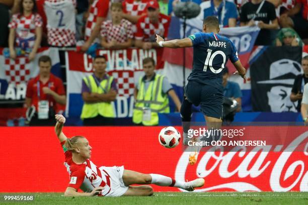 France's forward Kylian Mbappe and Croatia's defender Domagoj Vida vie for the ball during the Russia 2018 World Cup final football match between...