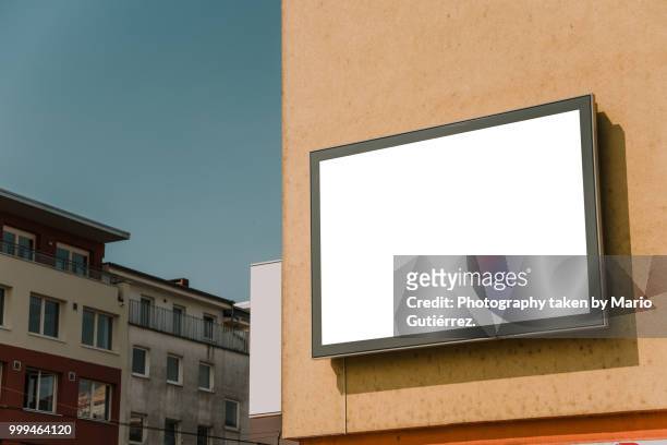 blank billboard on building facade - horizontal stock-fotos und bilder