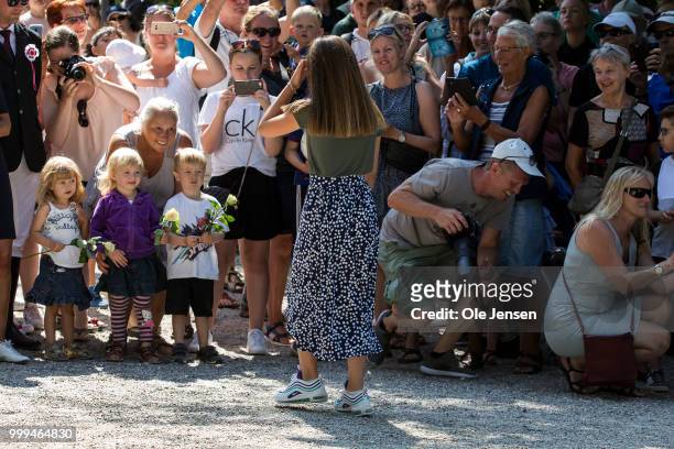 Princess Isabella walks to the bystanders to receives flowers from the kids seen when her and her family waits for greeting the Tilting-At-The-Ring...