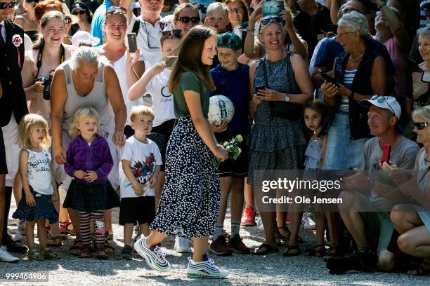 Princess Isabella after she received flowers from kids among the bystanders when her and her family waits for greeting the Tilting-At-The-Ring Riders...